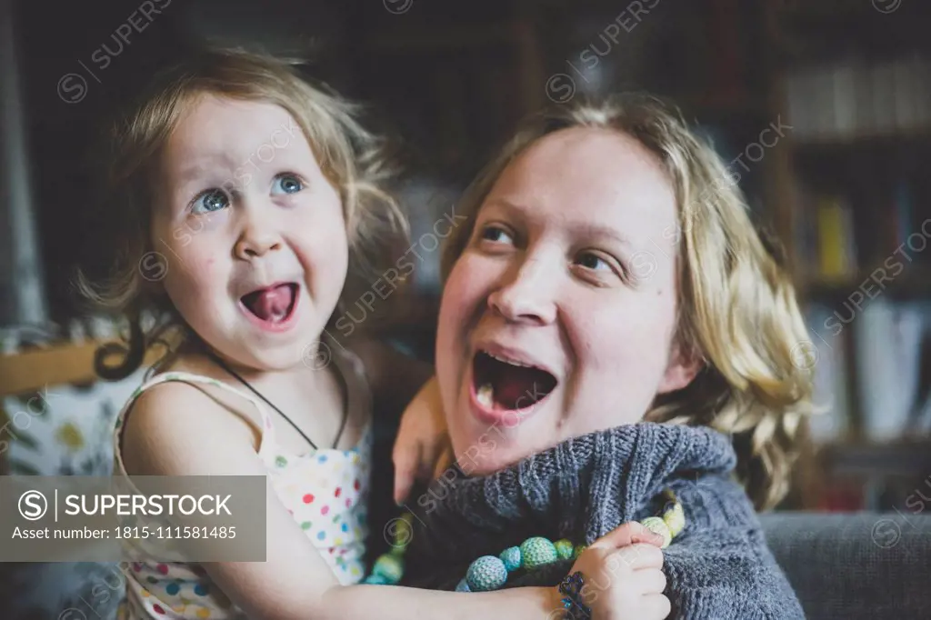 Portrait of mother and little daughter having fun together at home