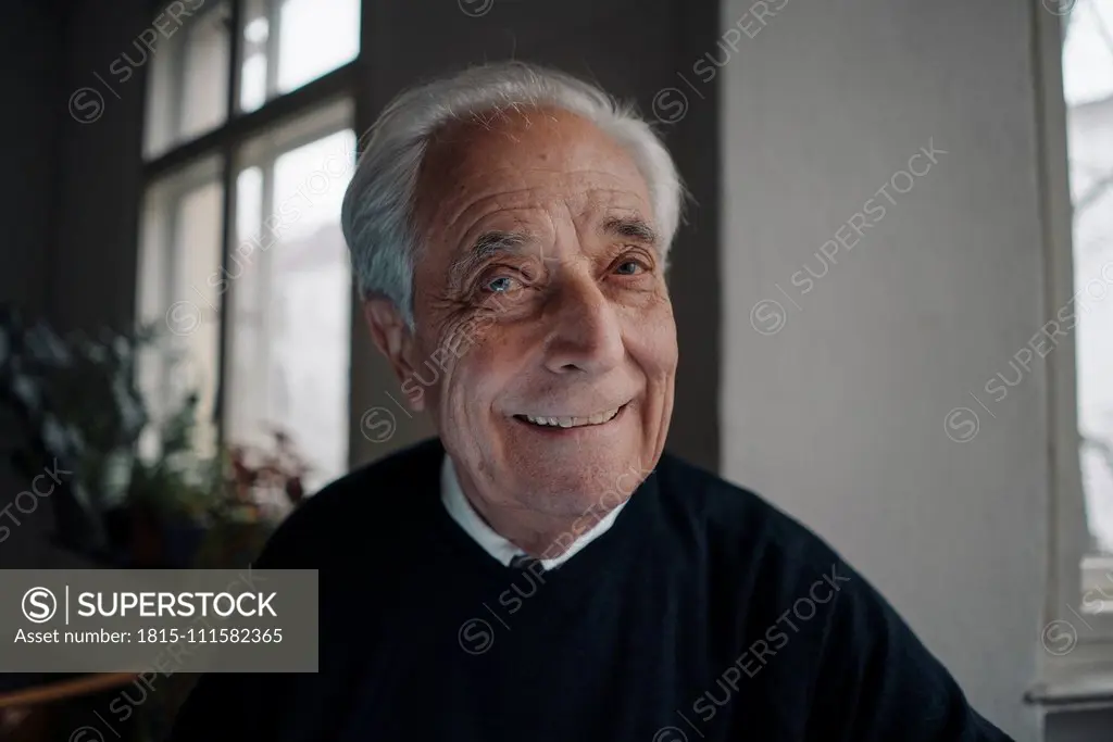 Portrait of smiling senior man at home