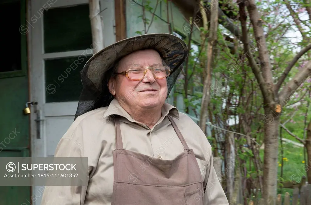 Rumania, Ciresoaia, Portrait of smiling beekeeper with beekeper's hood