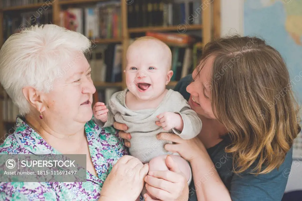 Happy grandmother and mother holding a baby girl