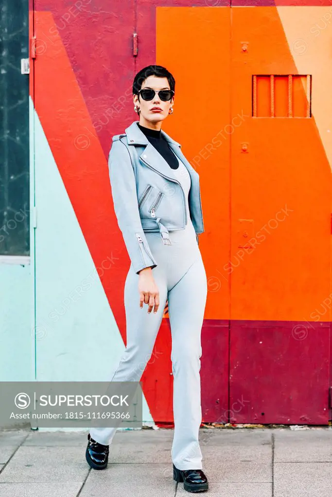 Fashionable young woman posing with colorful urban background