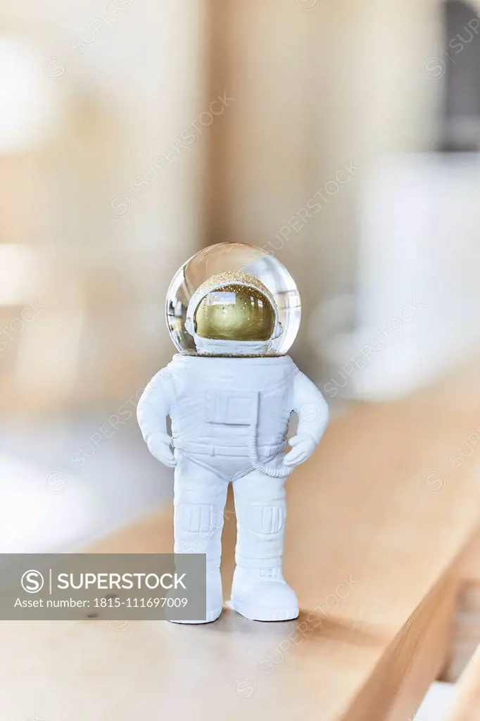 Miniature astronaut figurine on wooden bench