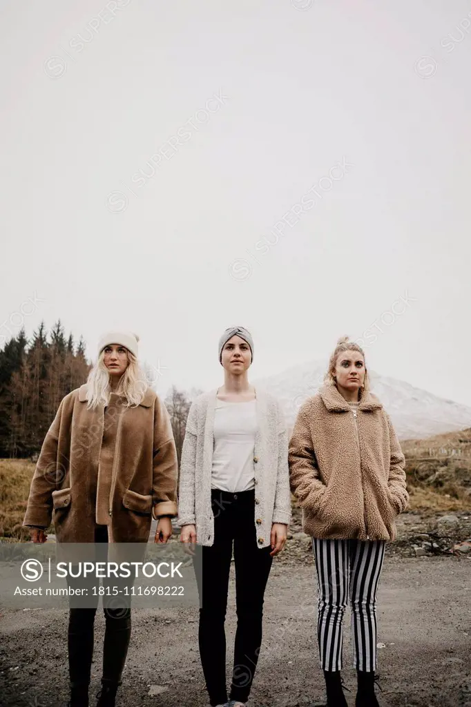 UK, Scotland, three young women standing on a path in rural landscape