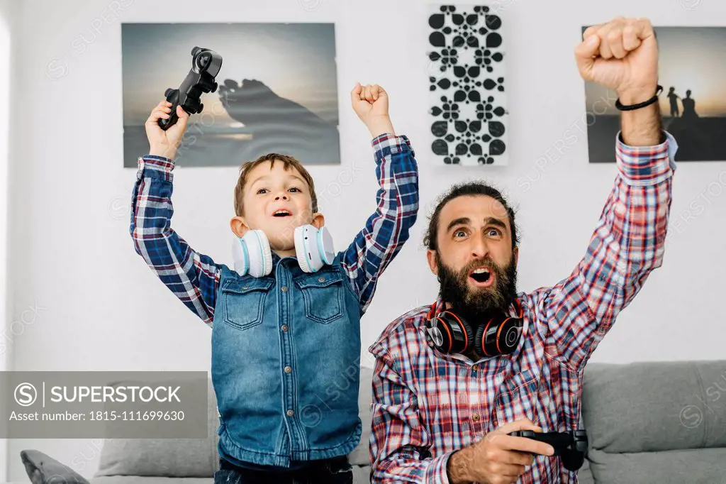 Portrait of father and son playing computer game at home