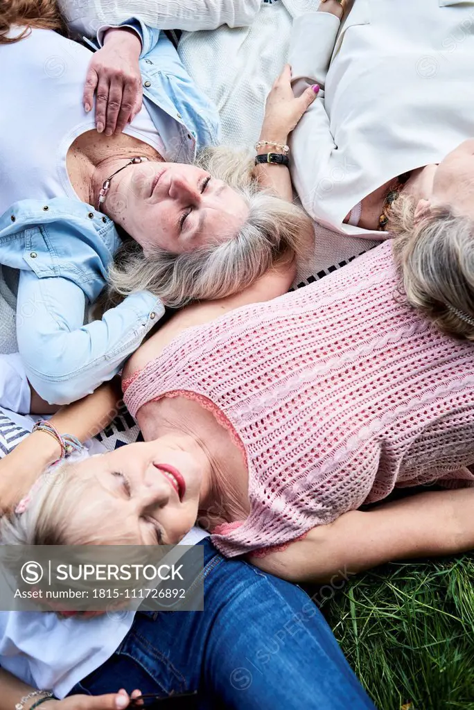 Top view of group of senior women lying in a meadow