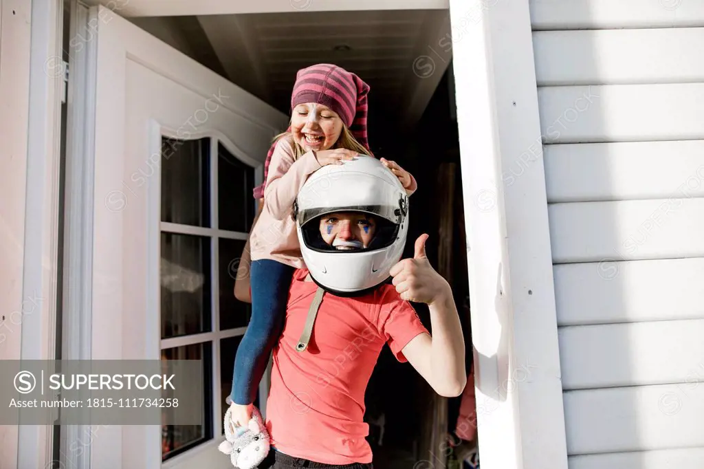 Portrait of boy and little sister made up for carnival having fun together