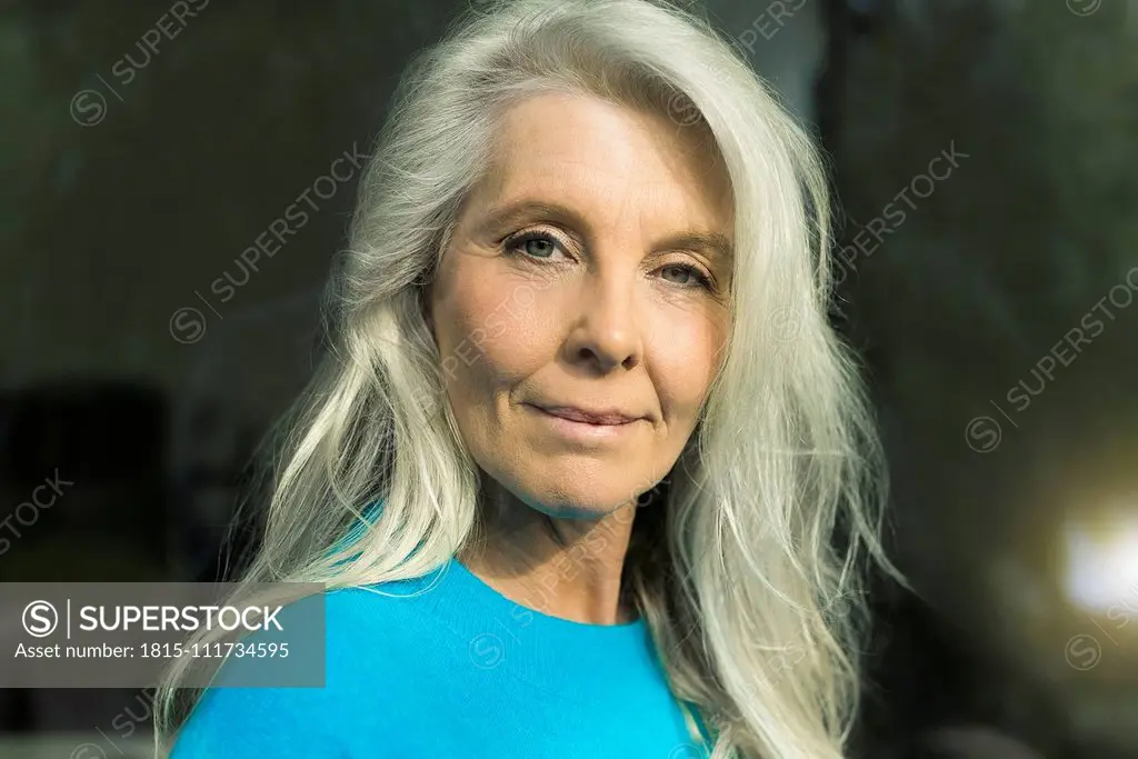 Portrait of content mature woman wearing blue pullover