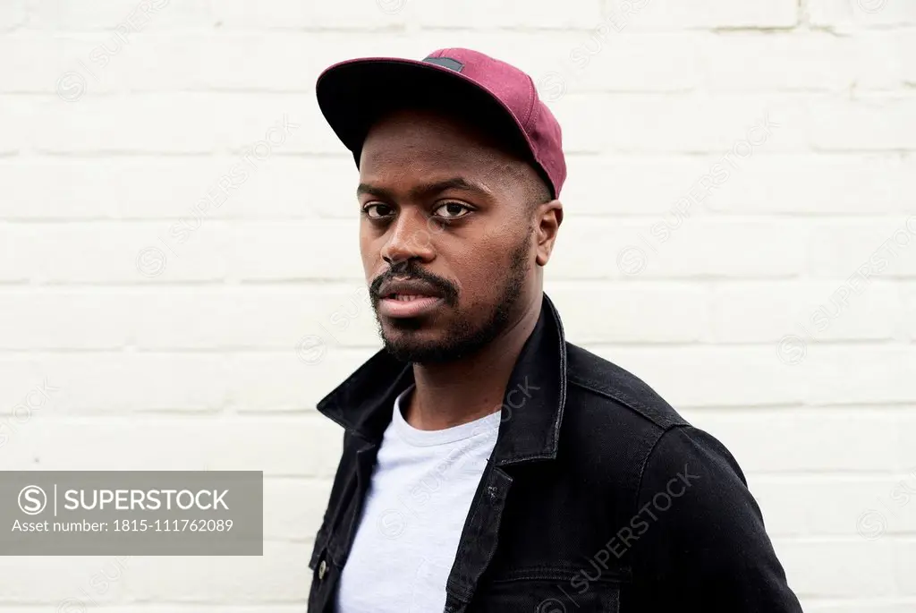 Portrait of mid adult man wearing denim jacket and basecap