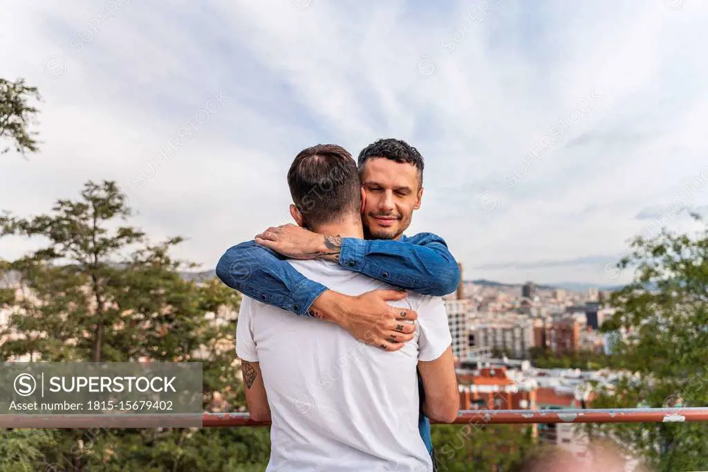 Portrait of happy man hugging his boyfriend, Barcelona, Spain