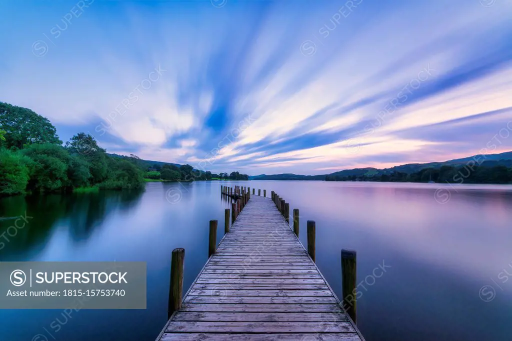 UK, England, Long exposure of clouds over jetty on¶ÿConiston Water lake at dusk