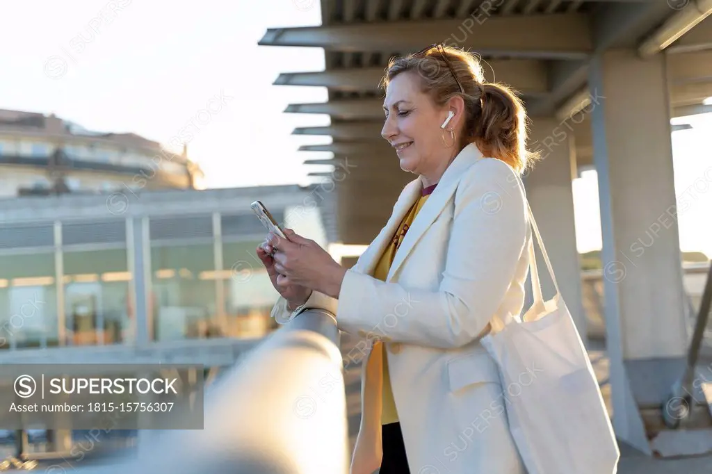 Senior businesswoman commuting in the city, using mobile phone