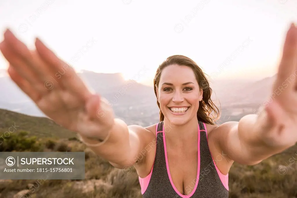 Portrait of happy Plus-Size-Model doing sports in the countryside at sunset