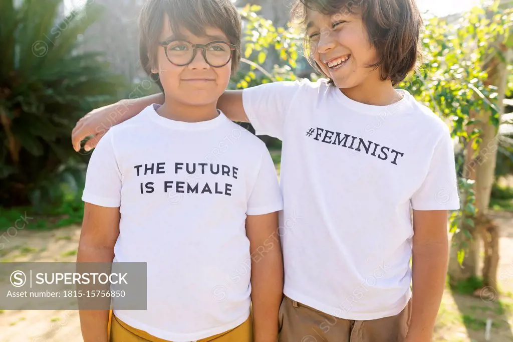 Two boys standing in the street with print on t-shirt, saying femininst and the future is female