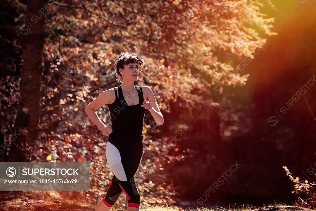 Woman jogging in autumn forest