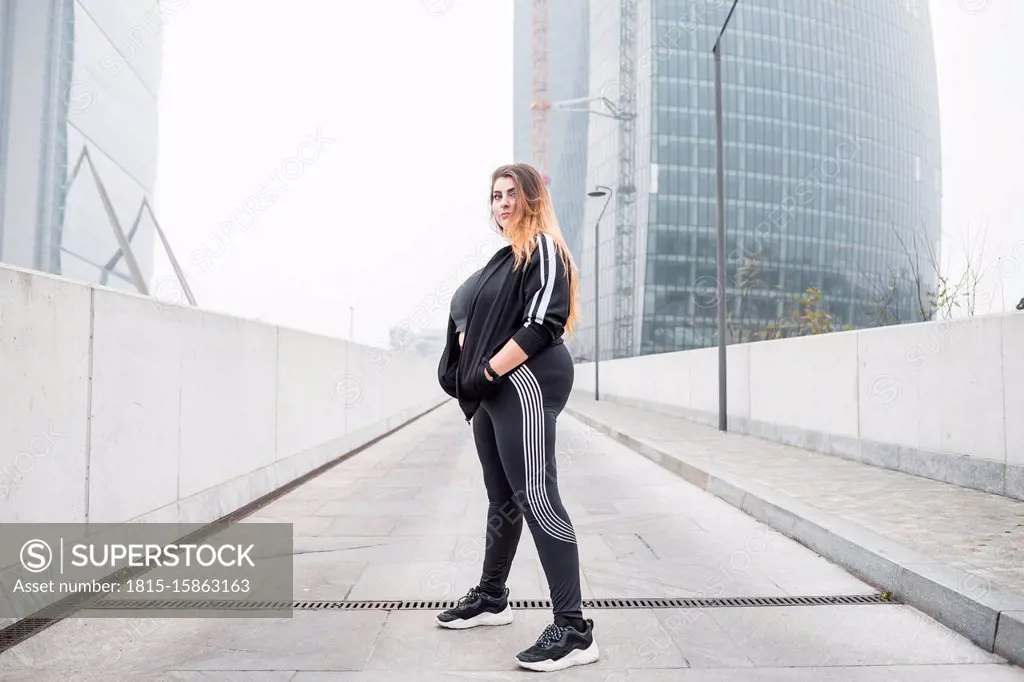 Plus size sportive young woman posing in the city