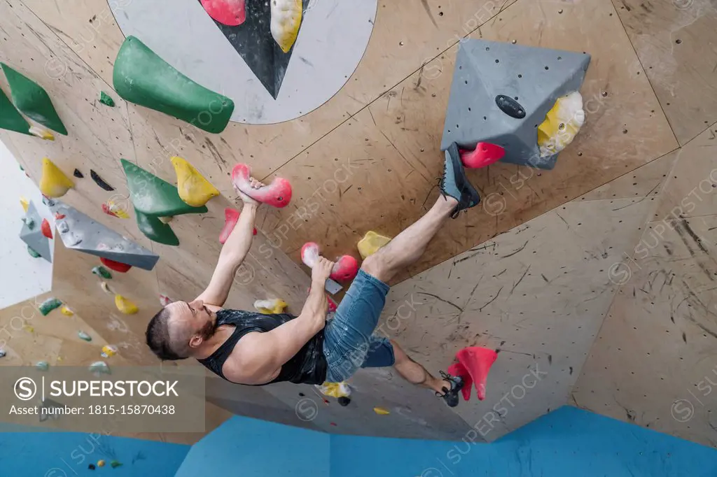 Man bouldering in climbing gym