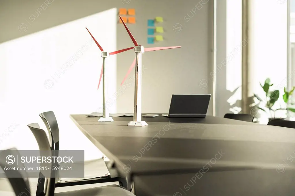 Wind turbine models and laptop on desk in office