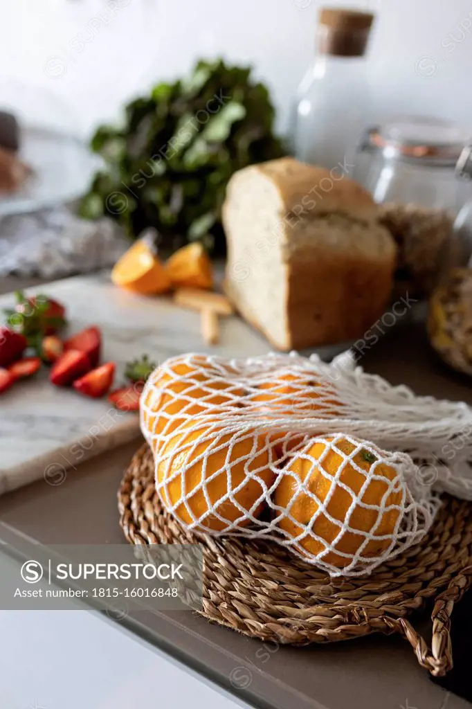 Oranges in net on kitchen counter