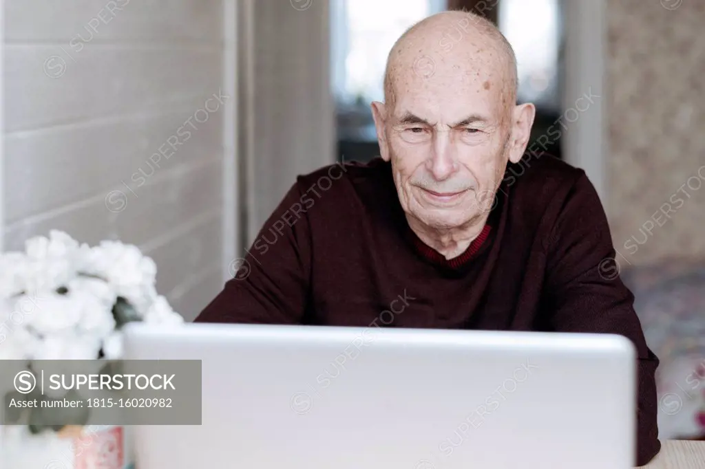 Portrait of an old man looking at laptop