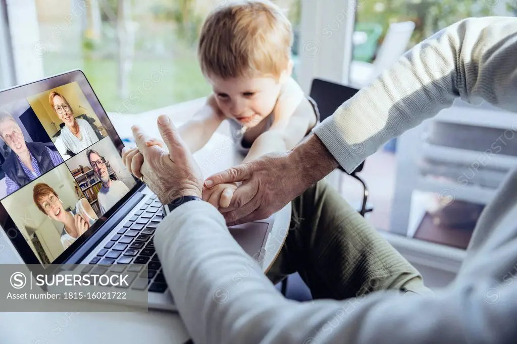 Little boy interrupting father's video conference at home