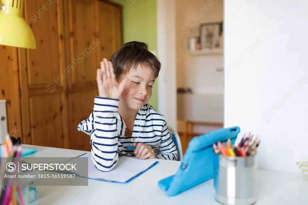 Boy doing homeschooling and using tablet at home