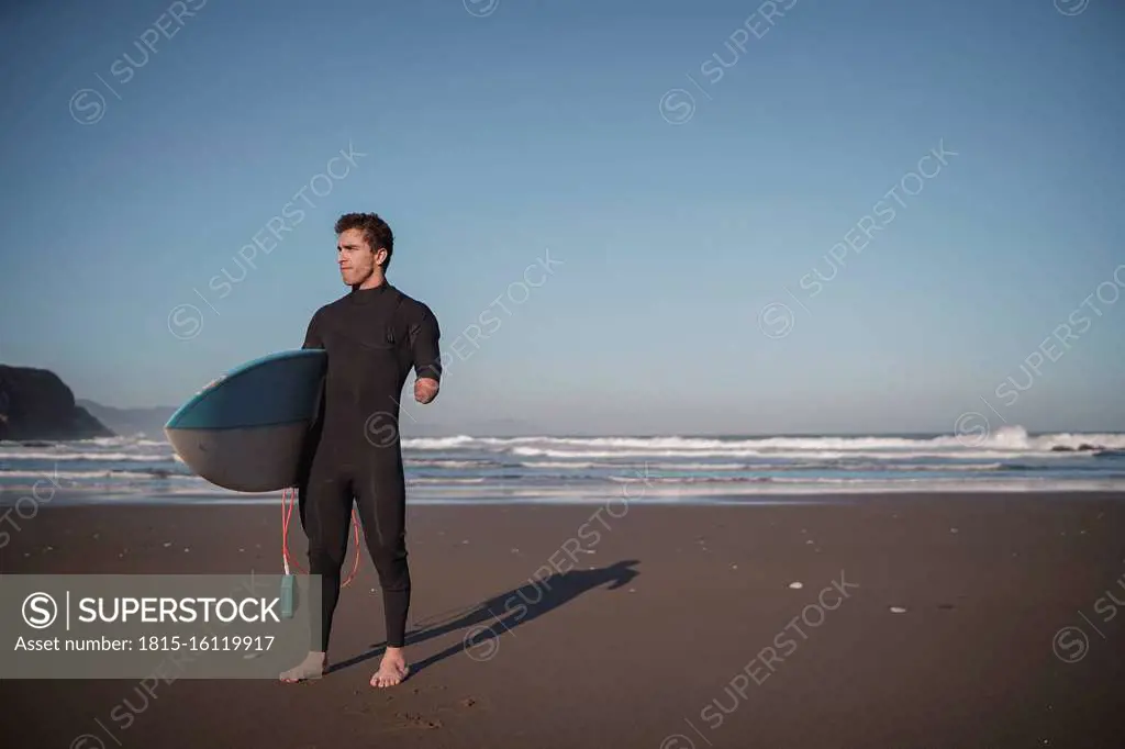 Handicapped surfer with surfboard at beach