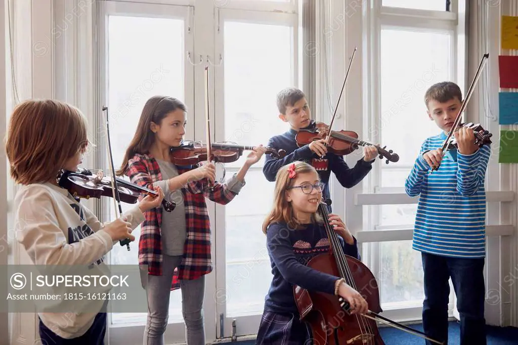 Group of children playing violin during a lesson