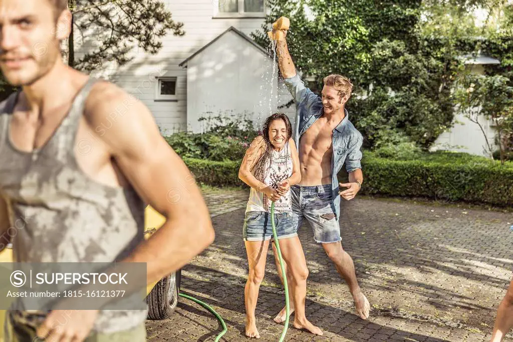 Friends washing car together having fun