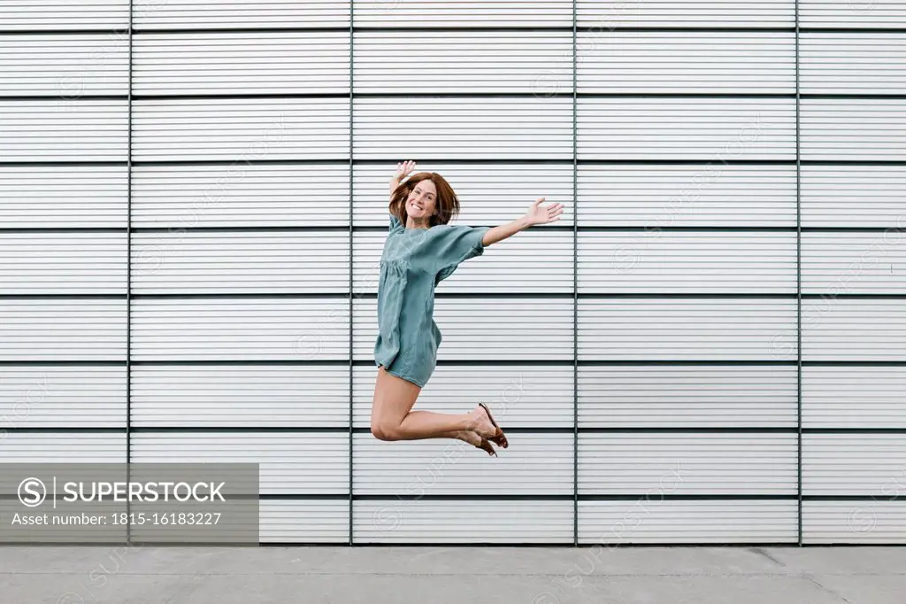 Happy redheaded woman jumping