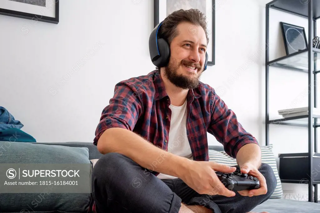 Man sitting on couch and playing video game