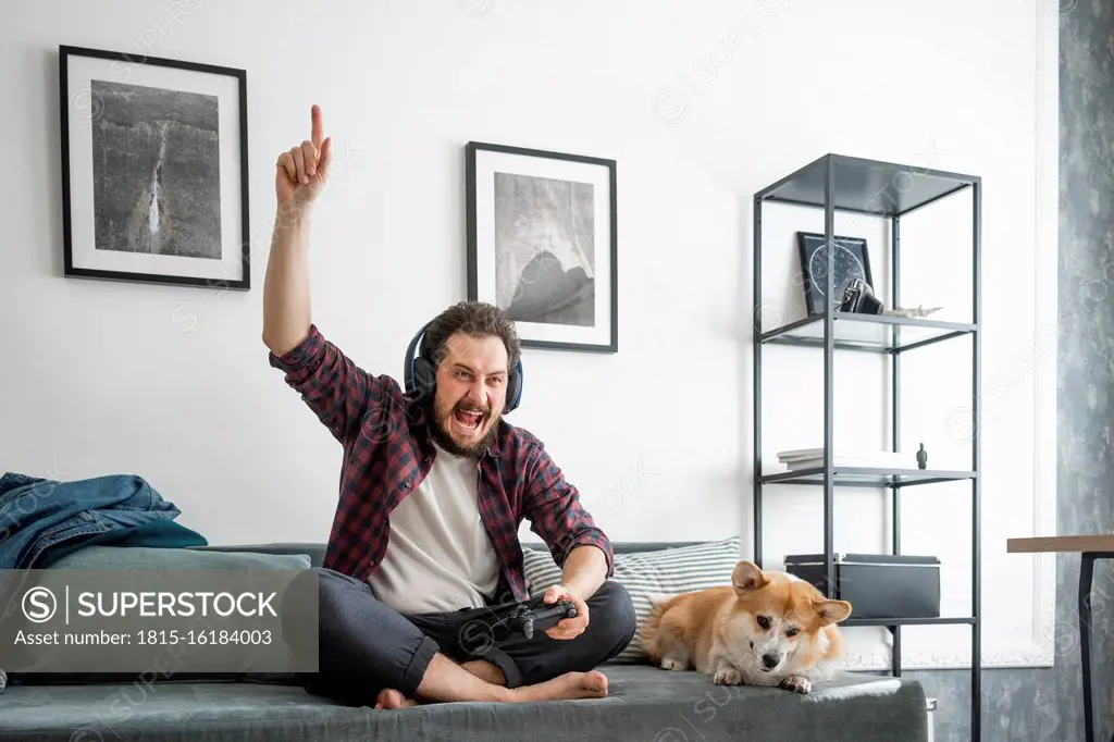 Man sitting on couch and playing video game