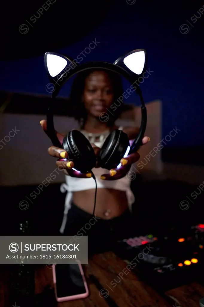 DJane showing her headphones with shining cat ears