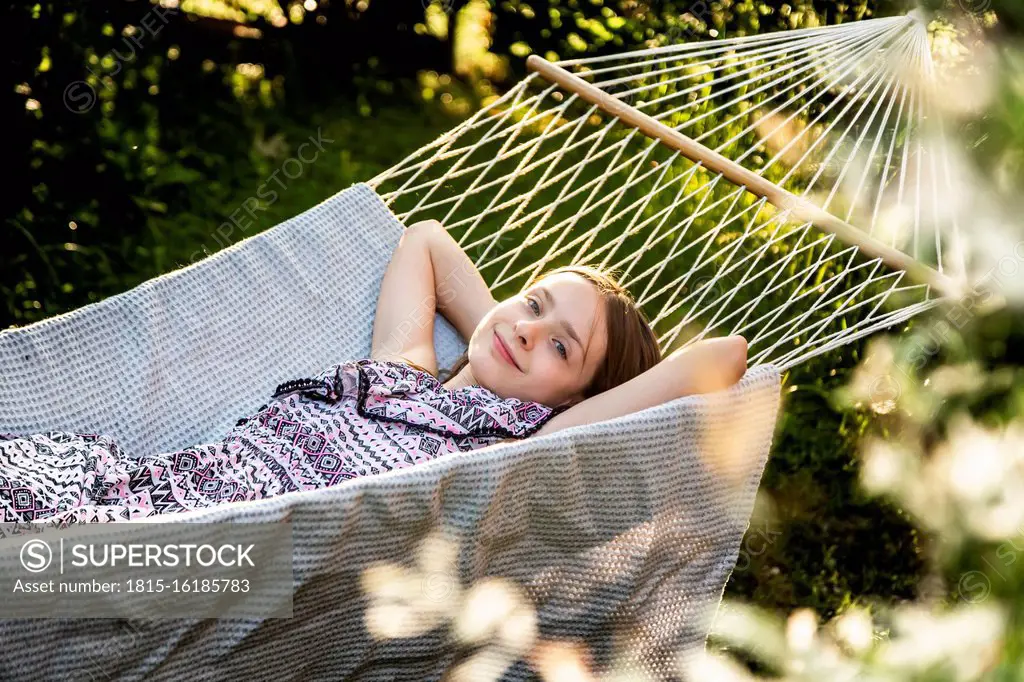 Germany, Bavaria, Landshut, Girl relaxing in hammock in garden