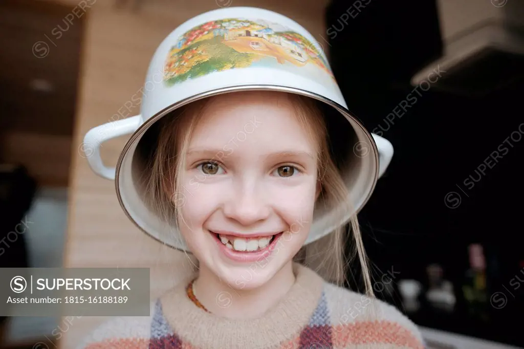 Portrait of playful girl with cooking pot o her head