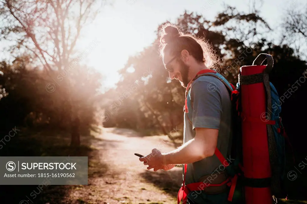 Bearded man with smartphone on a hiking trip