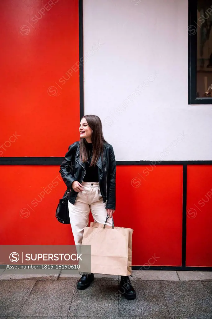 Happy young woman with shopping bags in the city