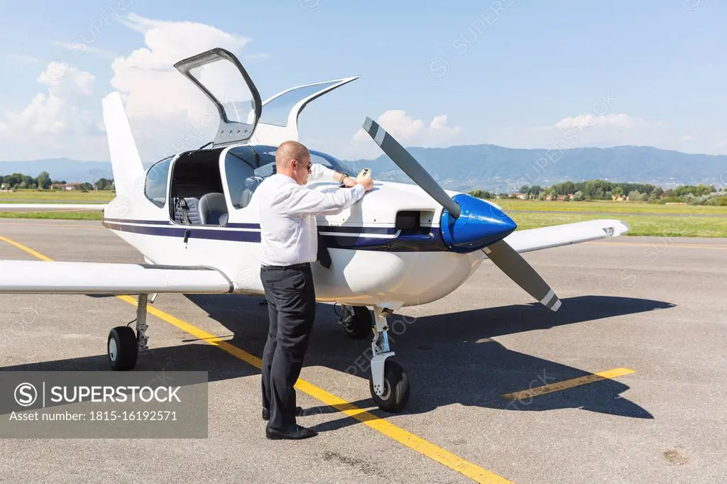 Pilot doing pre flight inspection on his sports plane