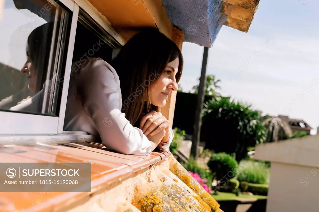 Woman leaning out of window of attic