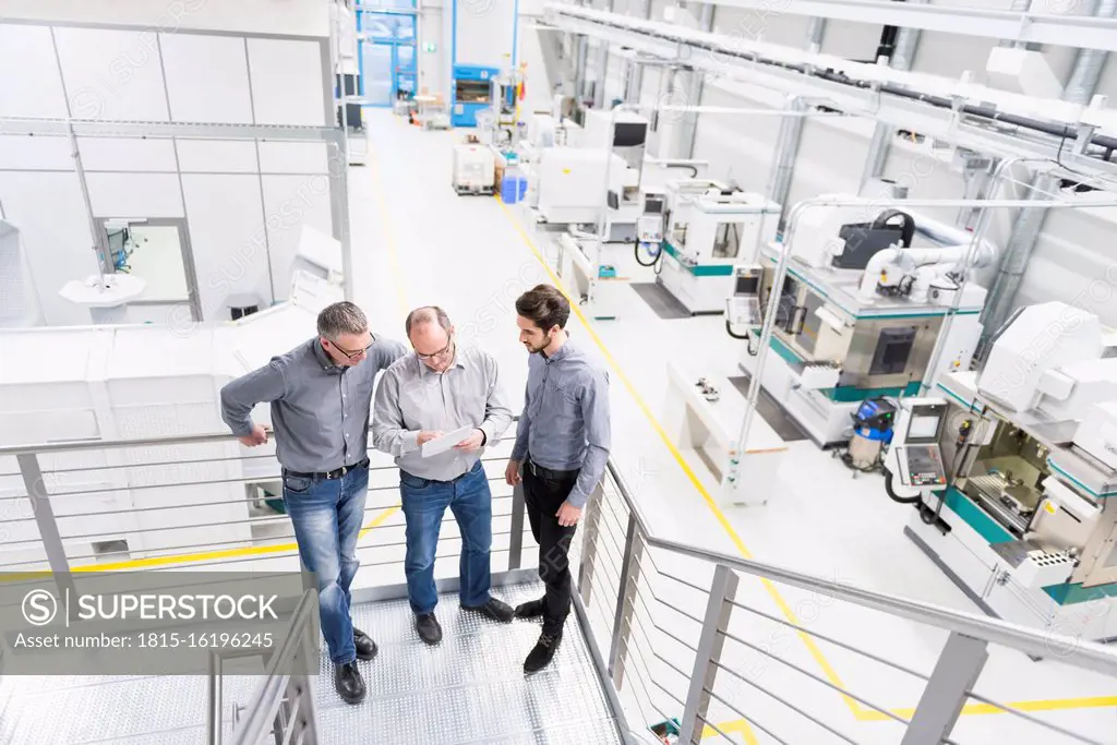 Three businessmen having a discussion in a factory