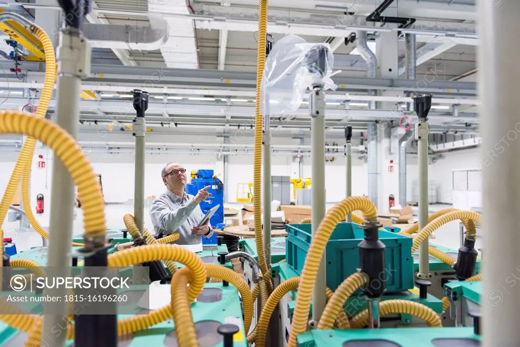 Businessman holding tablet in a factory