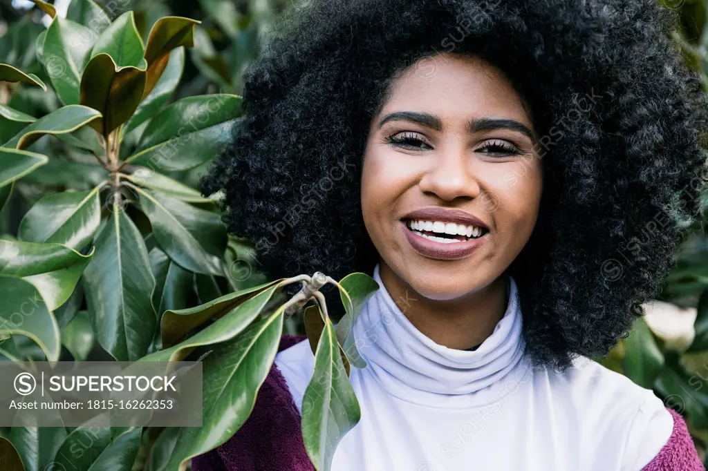 Close-up of cheerful young woman with afro hair in park