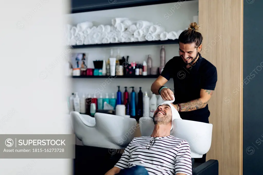 Hairdresser wrapped towel on client's hair at salon