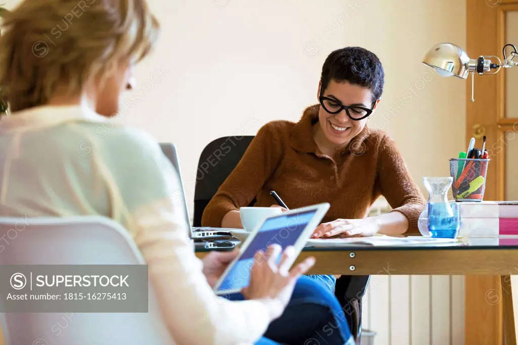 Businesswomen working in office using laptop and tablet