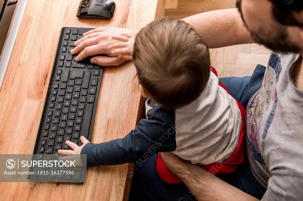 Father working from home with his baby on lap