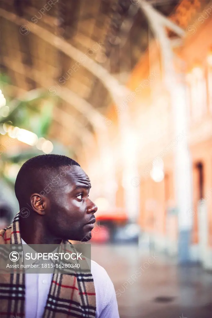 Serious thoughtful businessman looking away while standing at station