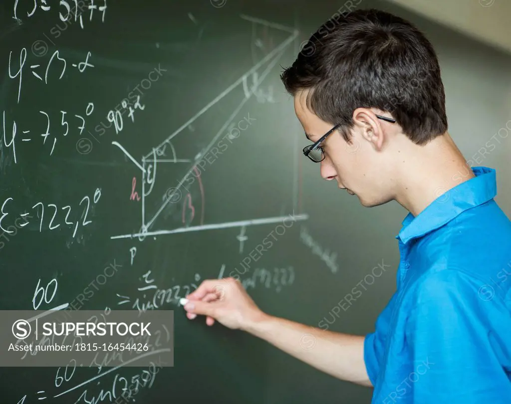 Austria, Student calculating at blackboard