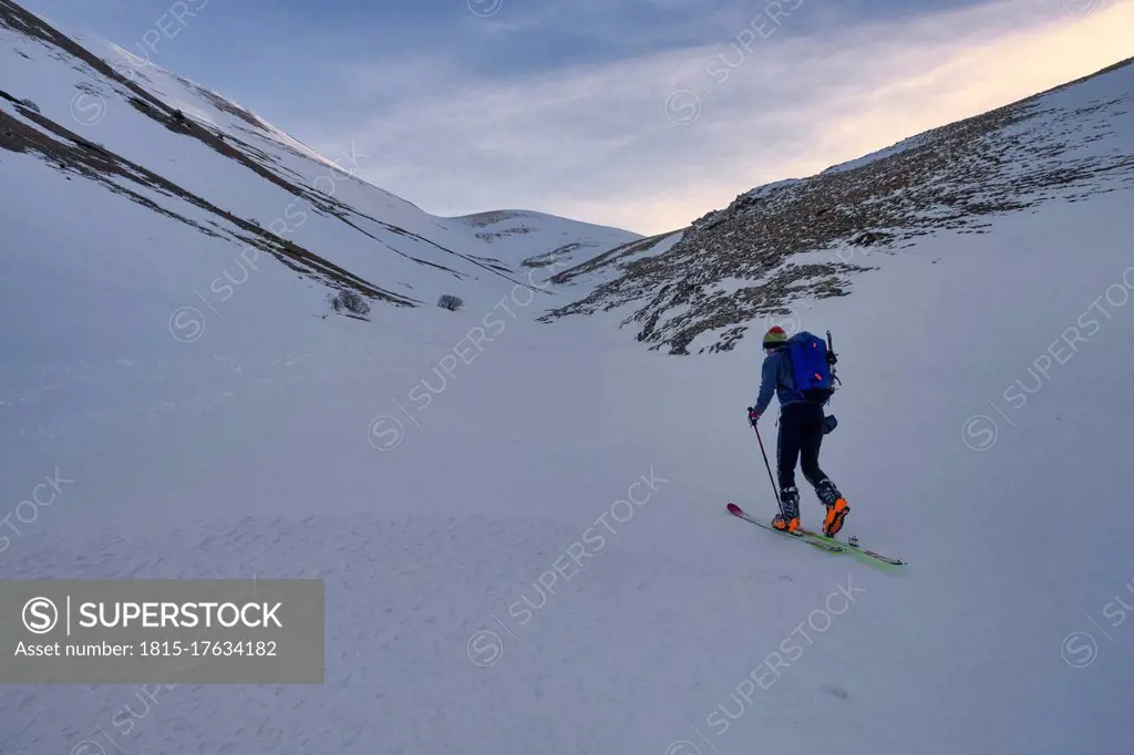 Young man cross-country skiing on Sibillini mountain at sunset, Umbrian, Italy