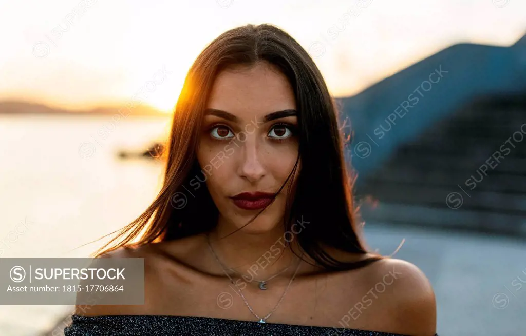 Beautiful woman standing at promenade during sunset