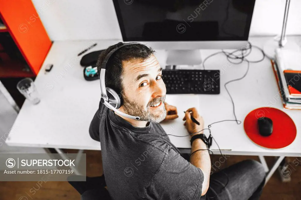 Man sitting on desk with headset working at home