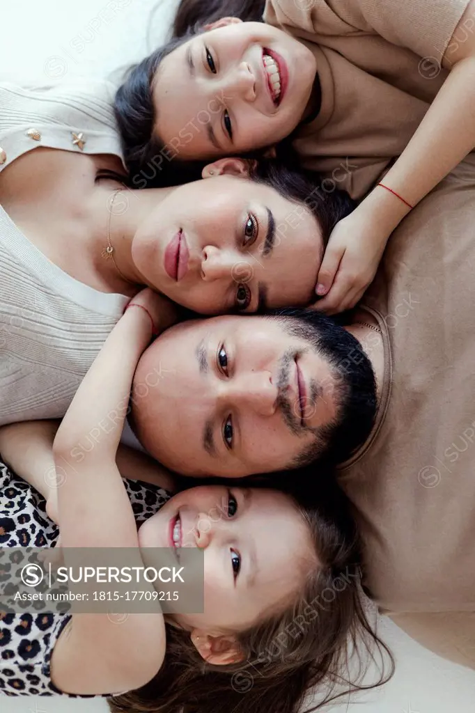 Children embracing parents while lying on floorr